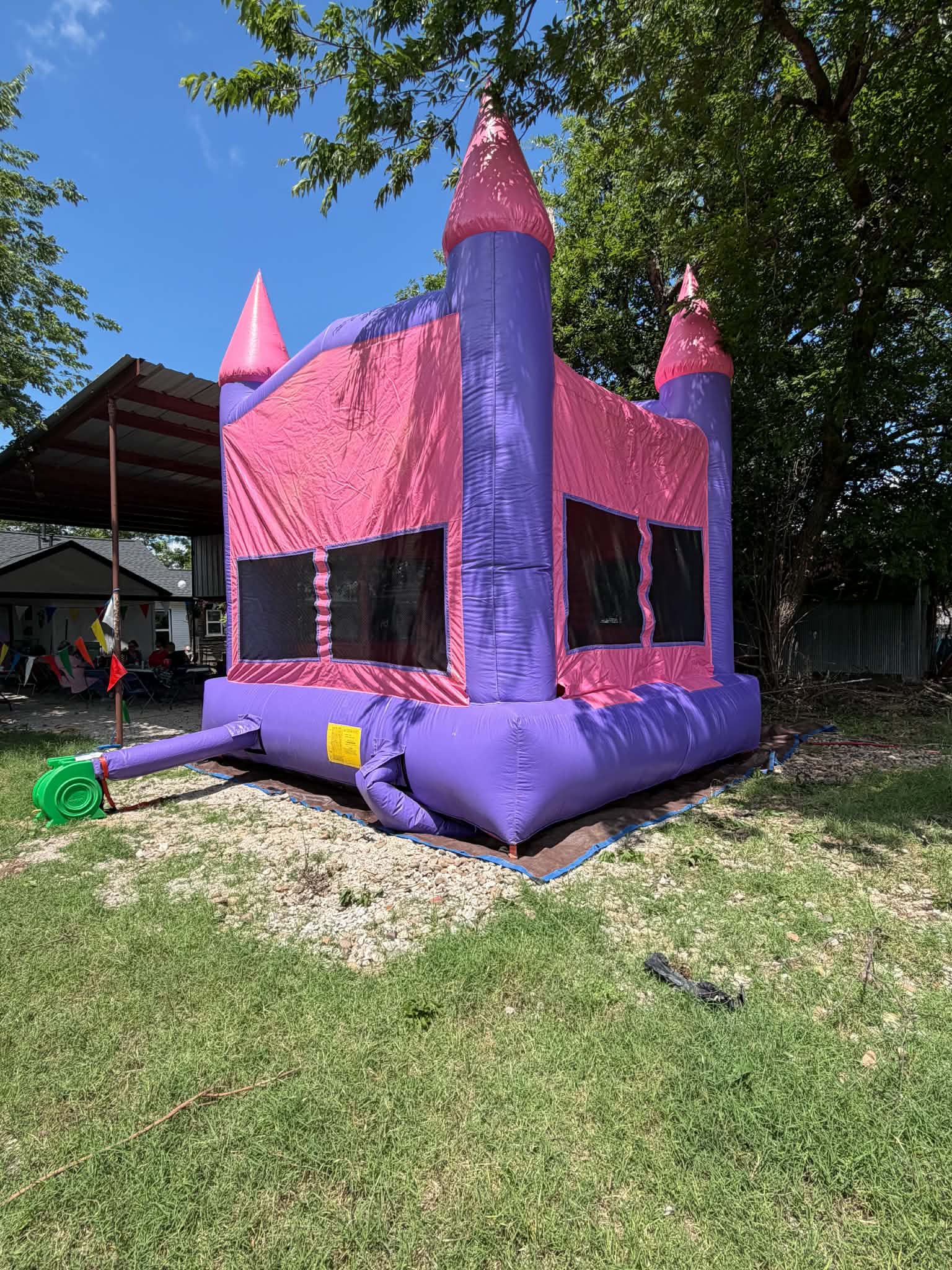 Pink and purple castle bounce house on grass
